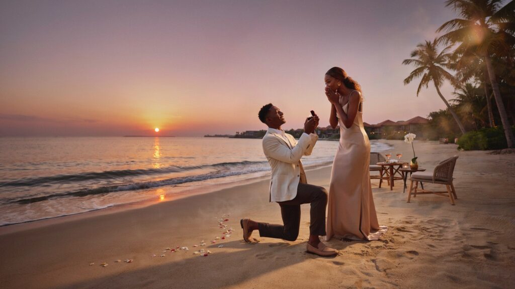 Man proposing to a woman on the beach at sunset